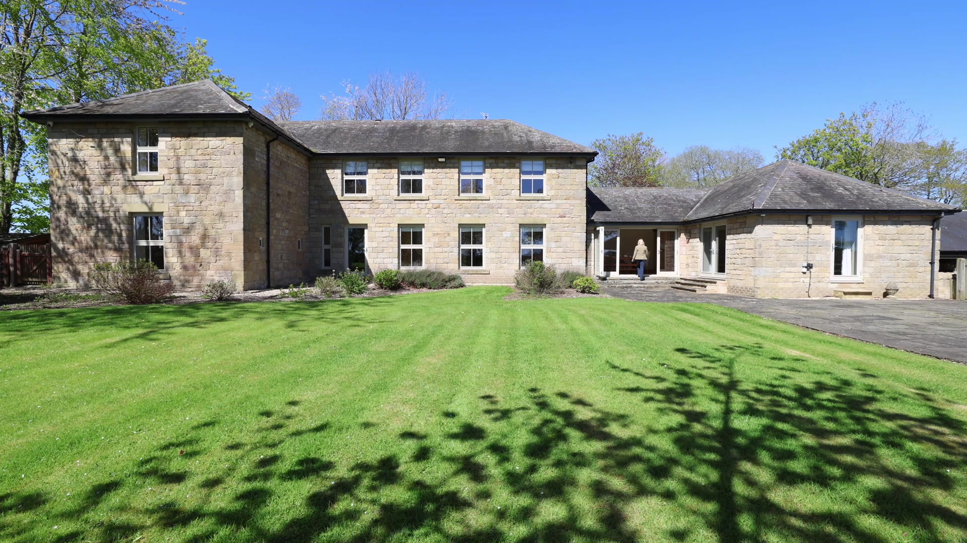 Stone farmhouse and lawn at East Thornton Farm near Morpeth, Northumberland.